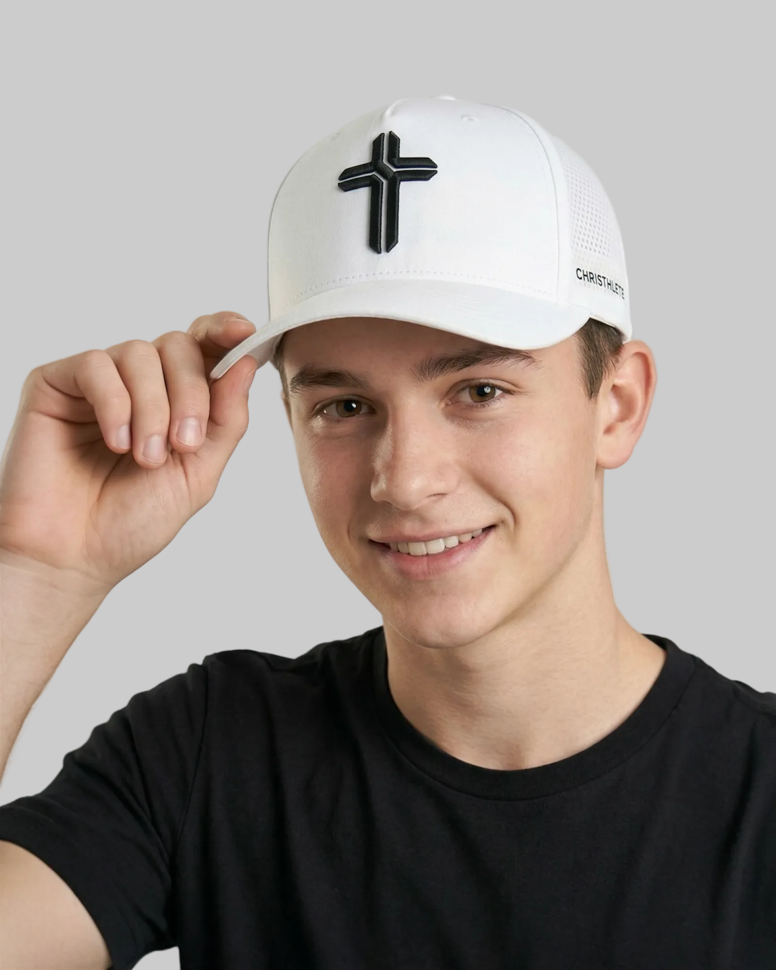 Image of Person wearing a white cap with a black cross design on a plain background