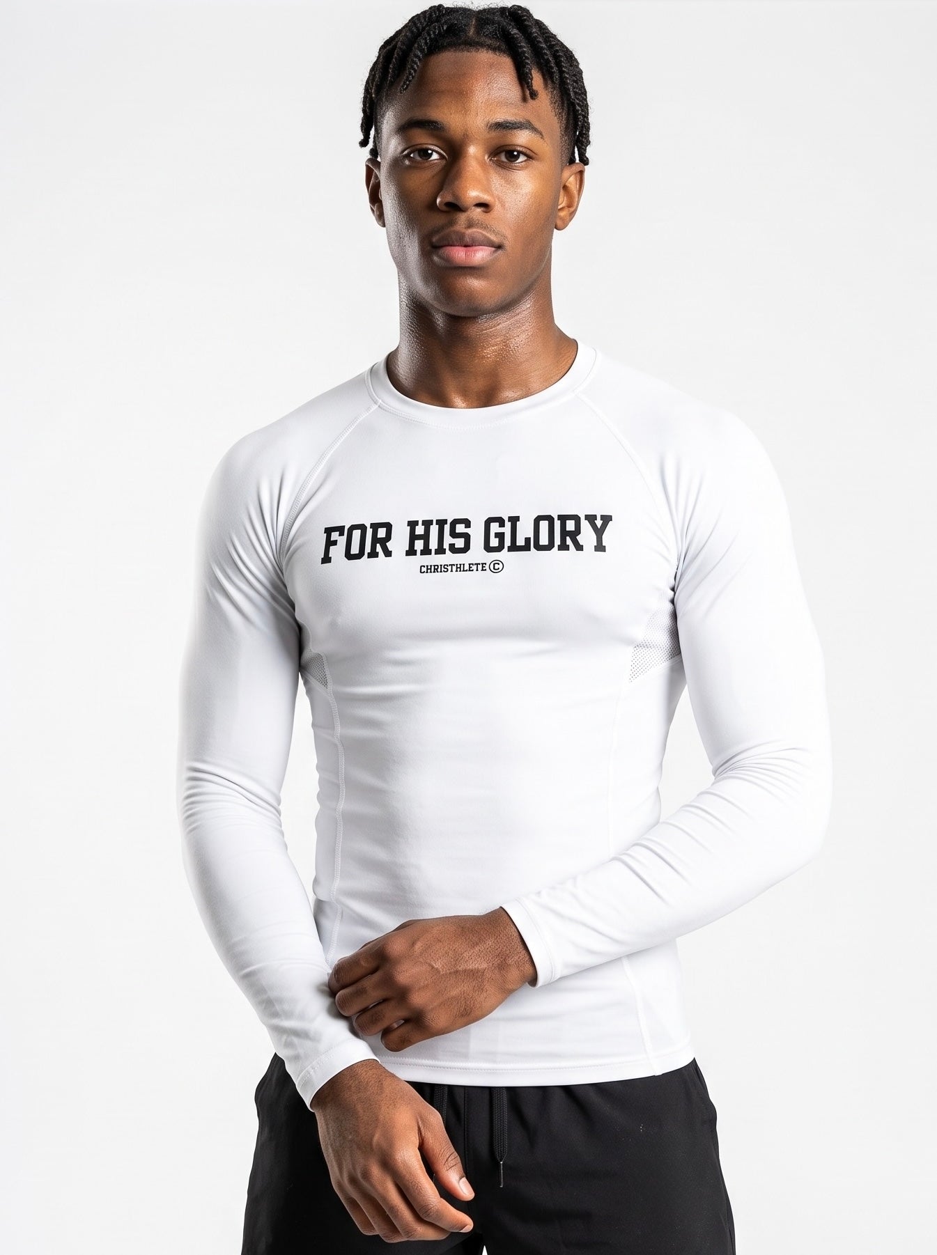 Image of A man wearing a white long-sleeve athletic compression shirt with 'FOR HIS GLORY' and 'CHRISTHLETE' printed in black across the chest, paired with black shorts, against a plain light gray background.