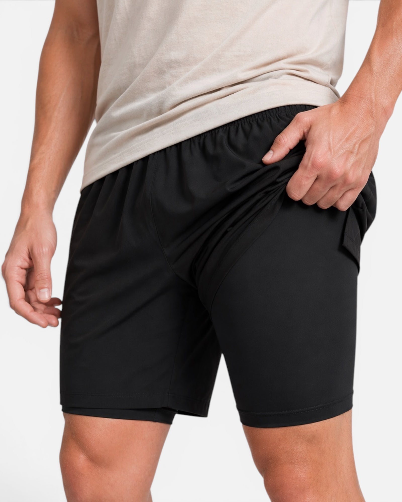Image of Person wearing black shorts and a beige shirt on a white background