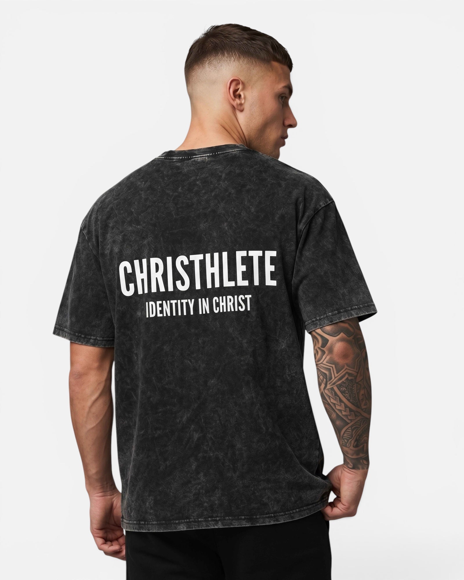 Image of Man wearing a black t-shirt with 'CHRISTHLETE Identity in Christ' text on the back against a white background